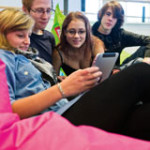 Four students using a tablet