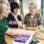 Three students sitting and talking at a table